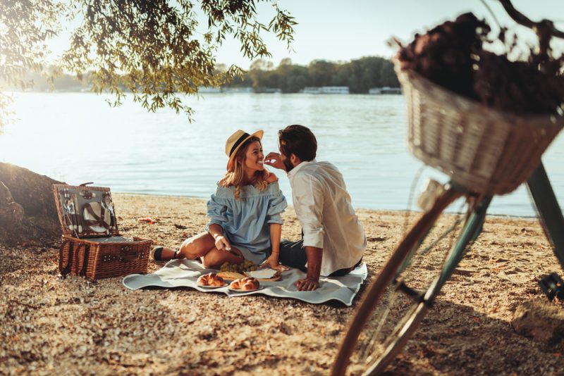 Par som älskar att njuta av picknicktid och mat utomhus