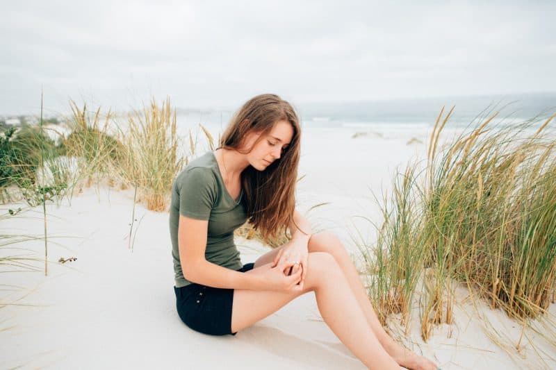 kvinna som sitter på sand