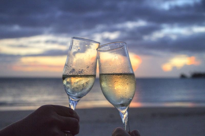 två personer som dricker vin nära havet