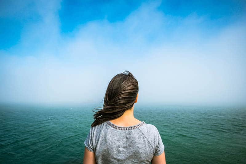 kvinna som står ensam och tittar på havet