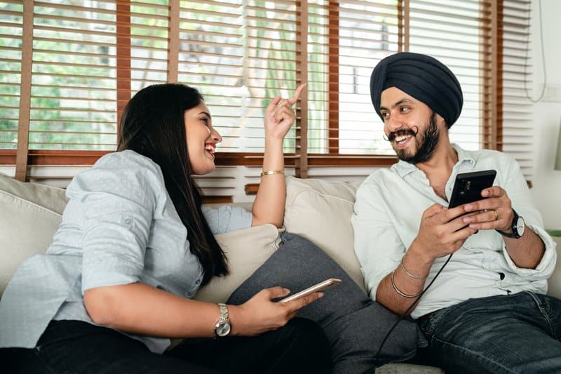 lyckliga indiska par med mobiltelefoner