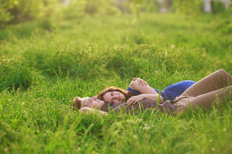 lyckliga par liggande på gräs