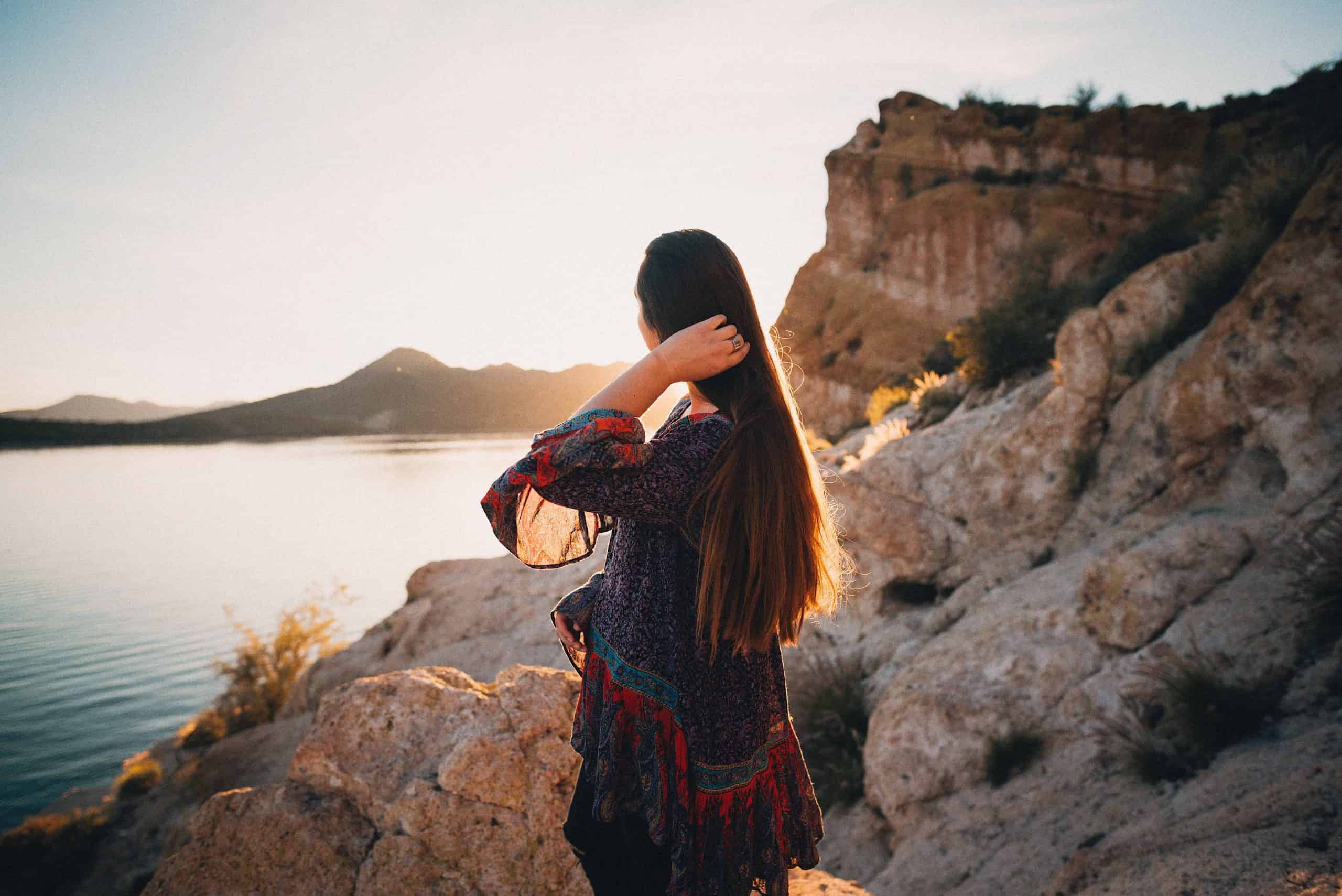 kvinna håller hår och tittar på sjön