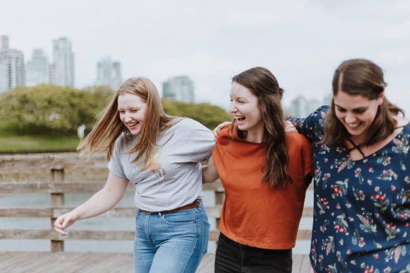 tre unga kvinnor ler