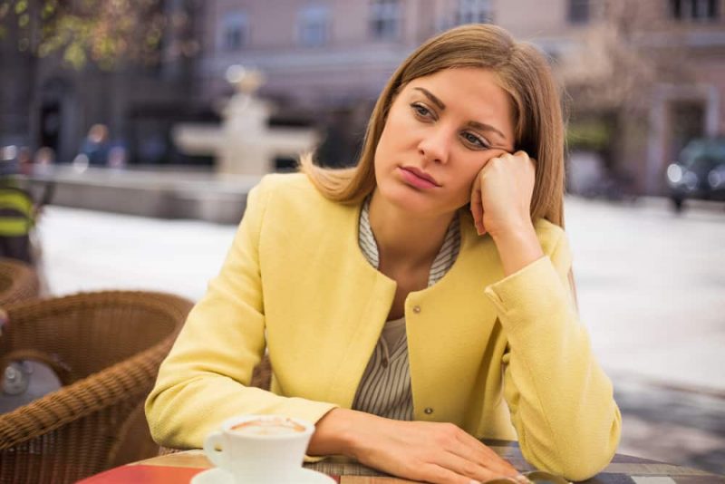 ledsen kvinna sitter ensam på caféet