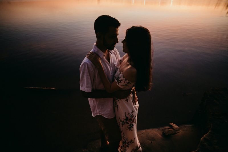man och kvinna som kramar vid vattnet
