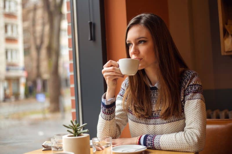 kvinna som dricker kaffe på café