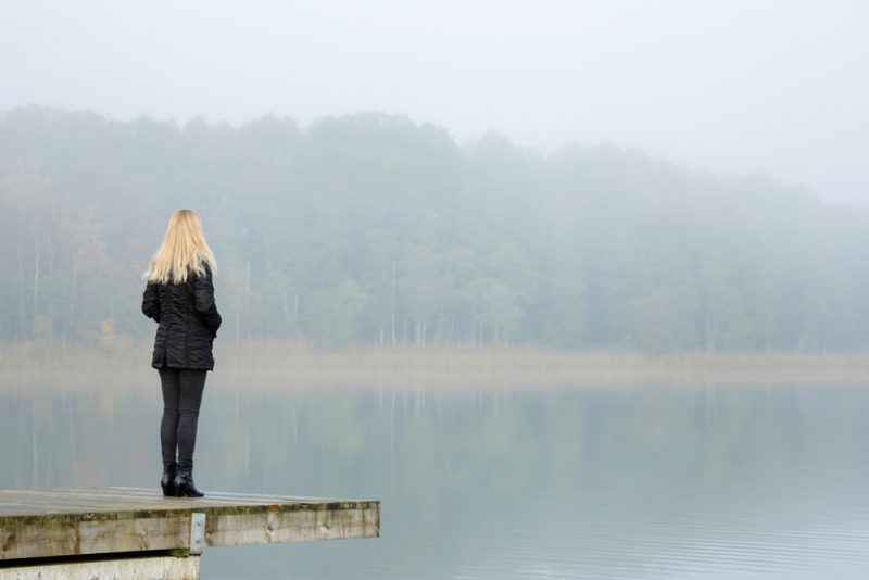 blond kvinna som bär svart jacka som står ensam