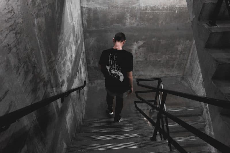 man som bär svart skjorta går nerför trappan