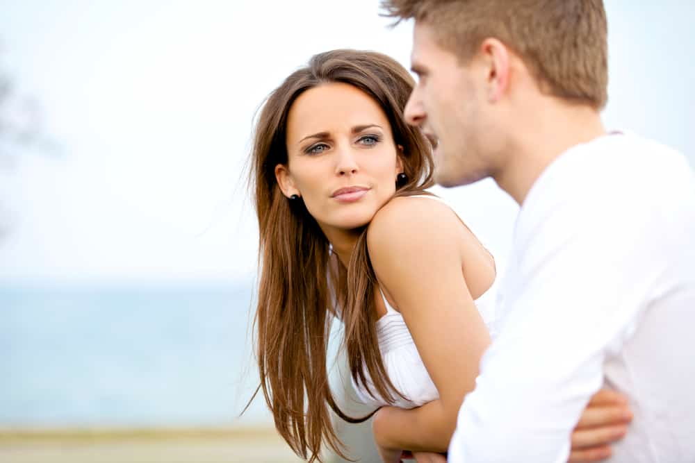 Stående av en attraktiv kvinna som allvarligt lyssnar på sin pojkvän medan hon är på ett datum