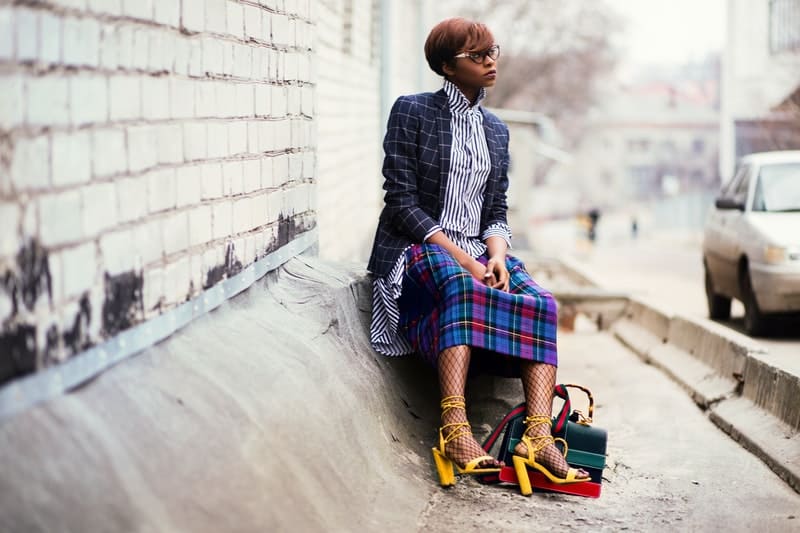 svart kvinna i kjol som sitter på gatan