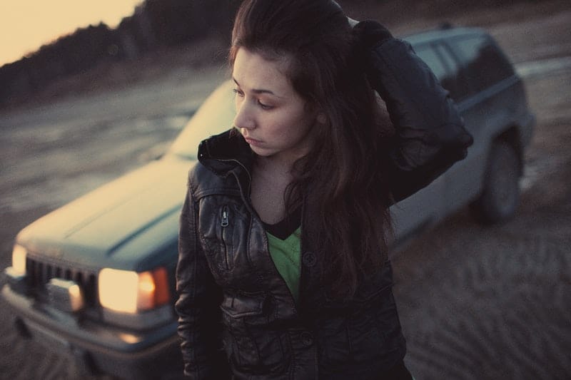 tankeväckande kvinna som står bredvid en bil