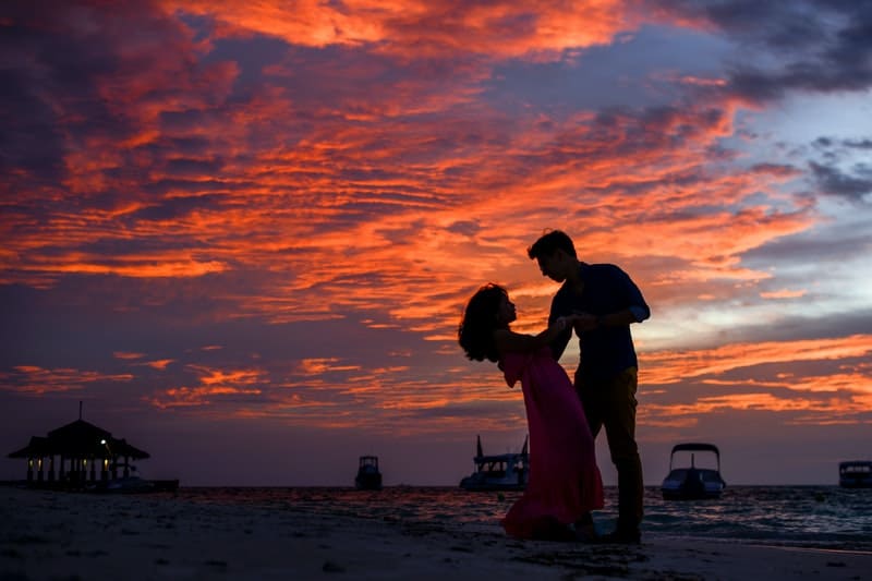 man och kvinna på stranden under solnedgången