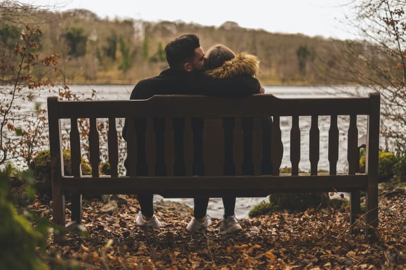 par som sitter nära sjön och kysser