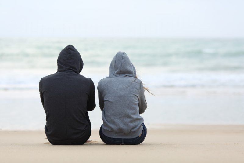 par tittar på horisonten medan de sitter på stranden