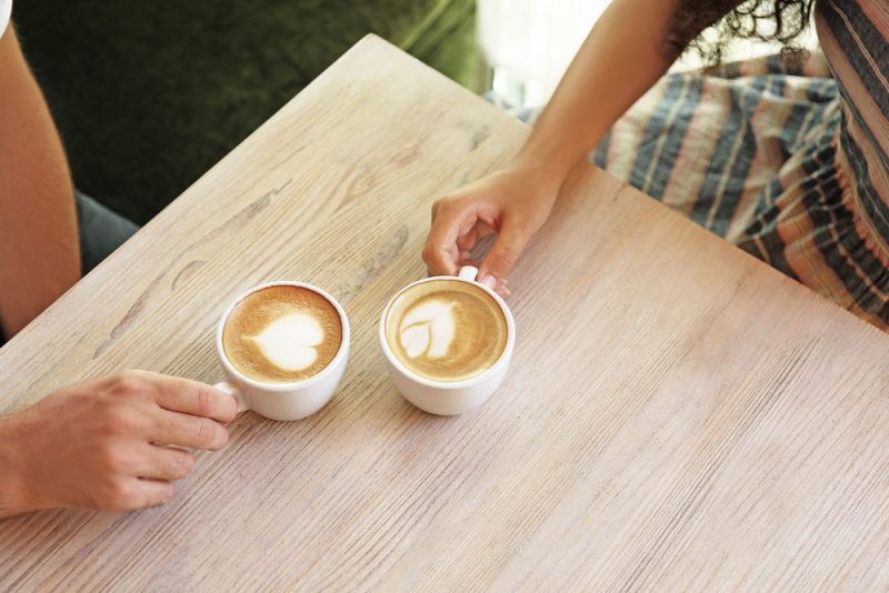 Händer som håller koppar kaffe