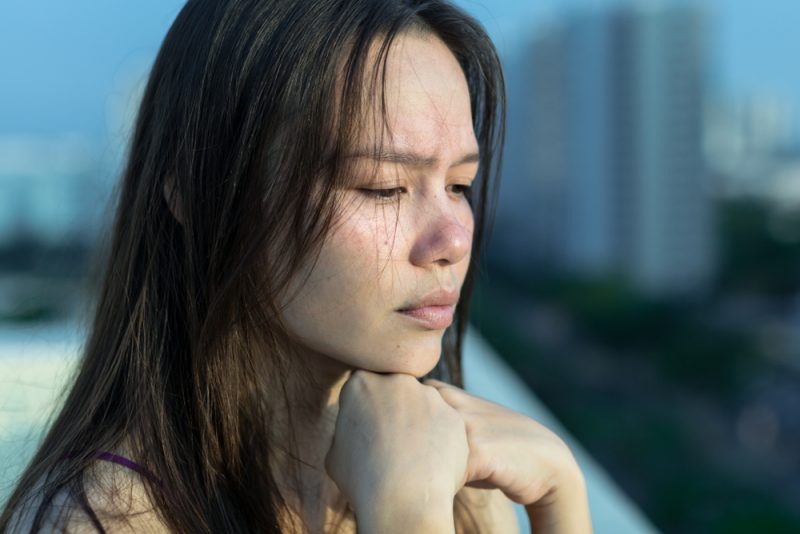 Ledsen kvinna deprimerad på hennes balkong