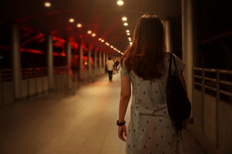 kvinna som bär grå klänning som går ensam