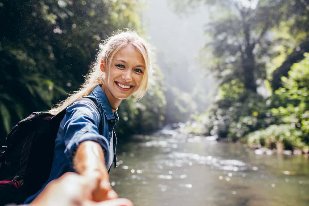 blond kvinna som håller handen i floden