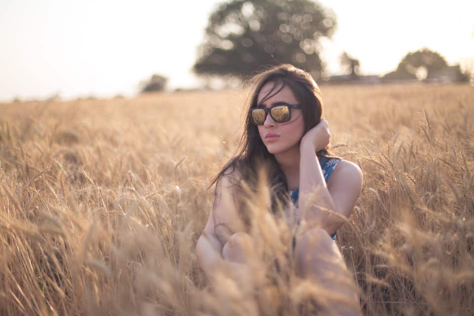 kvinna i glasögon som sitter i fältet