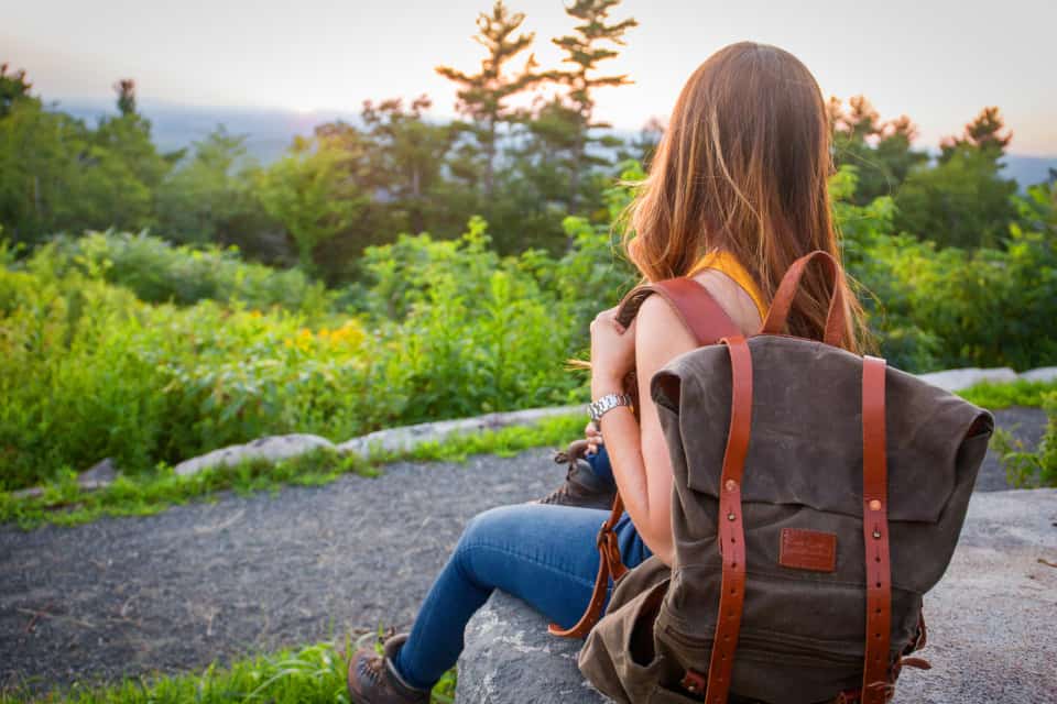 kvinna med ryggsäck som tittar på naturen