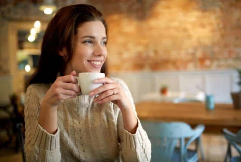 kvinna på ett kafé som dricker kaffe