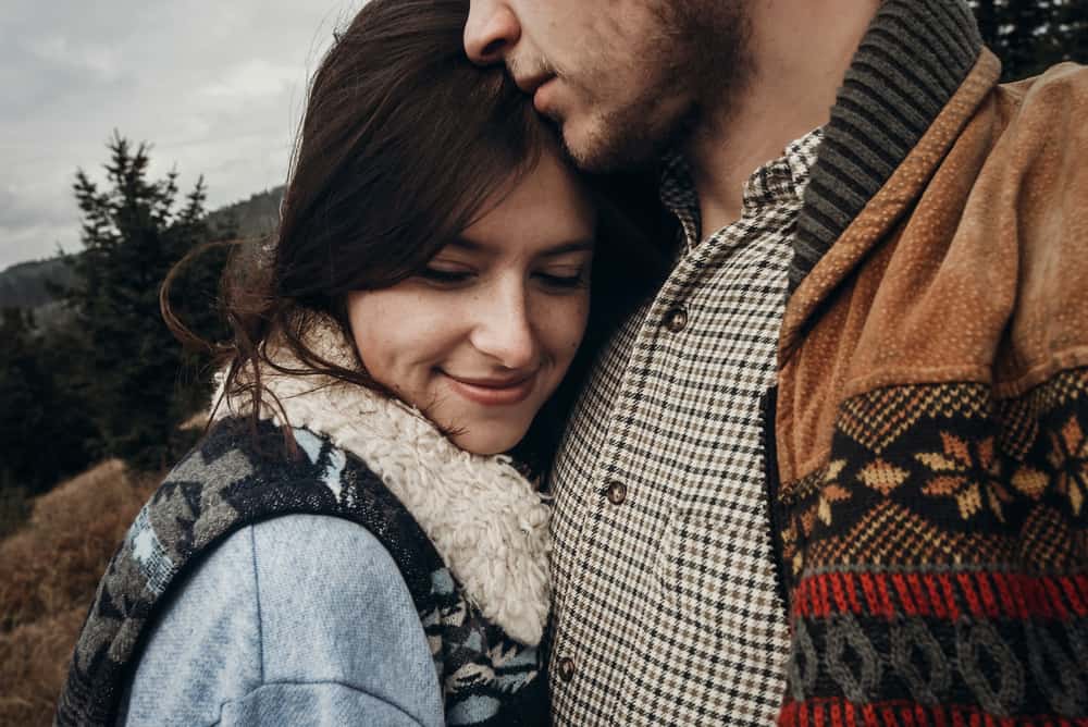 man och kvinna kram på vintern