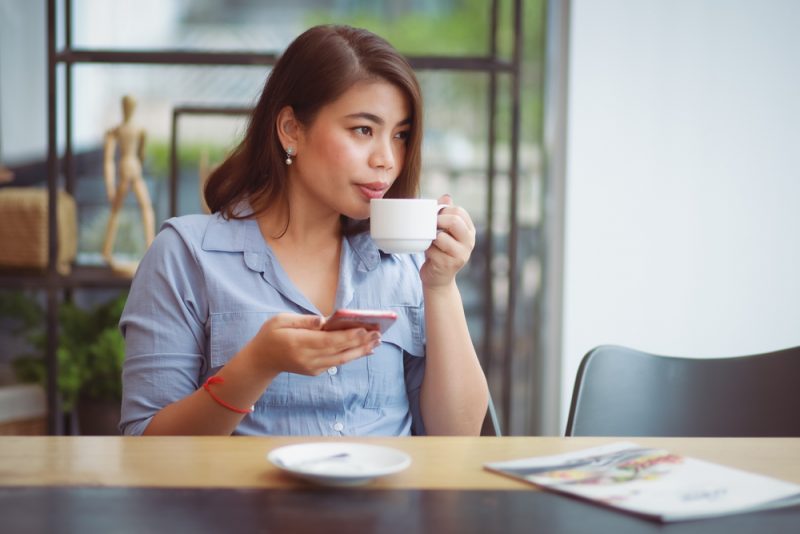 vacker kvinna som sitter på café och dricker kaffe