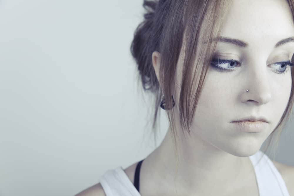 Ett närbildsporträtt av en attraktiv ung kvinna med en sorglig blick i ansiktet