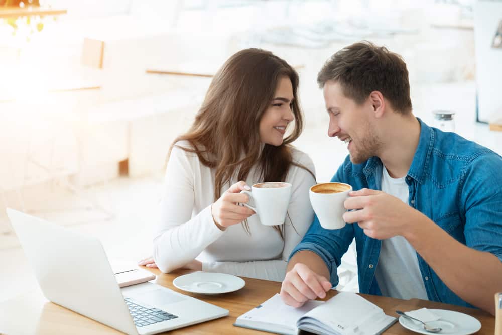 kvinna med bärbar dator och man som har kaffe tillsammans