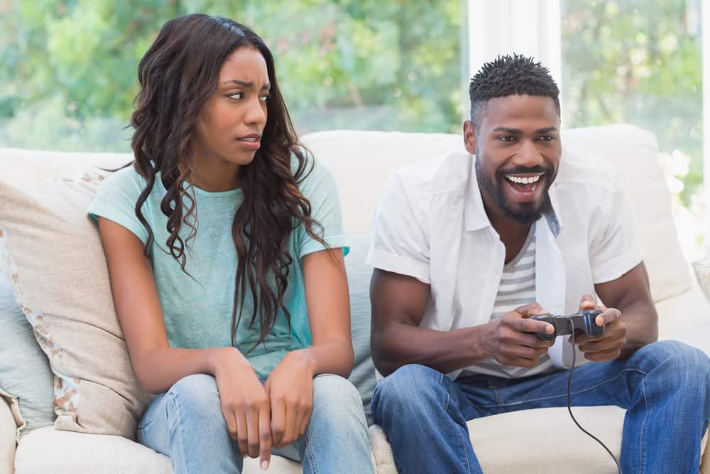 kvinna upprörd över mannen som spelar videospel