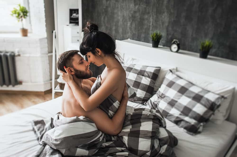 man och kvinna kela i sängen efter att ha älskat