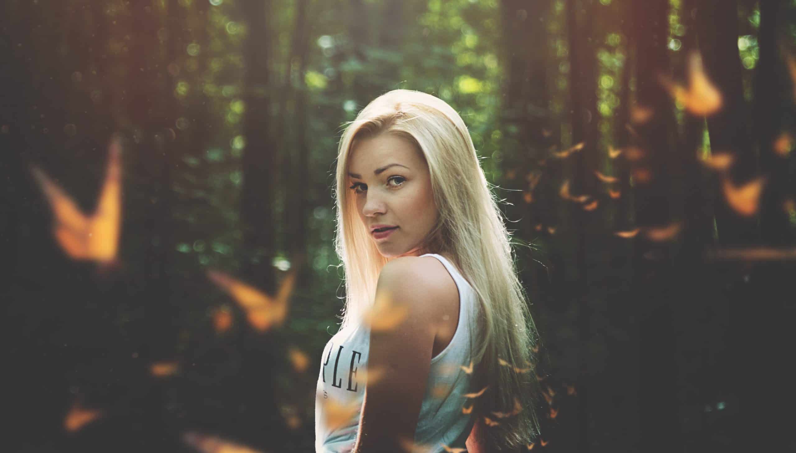 ung blond kvinna poserar i skogen