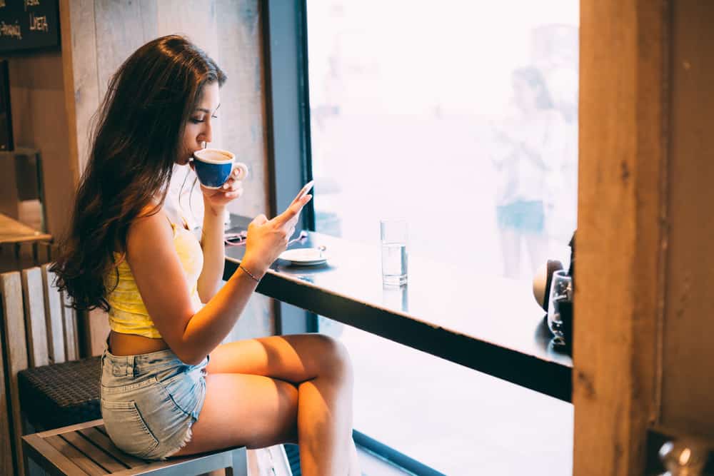 SMS för ung kvinna i kafé