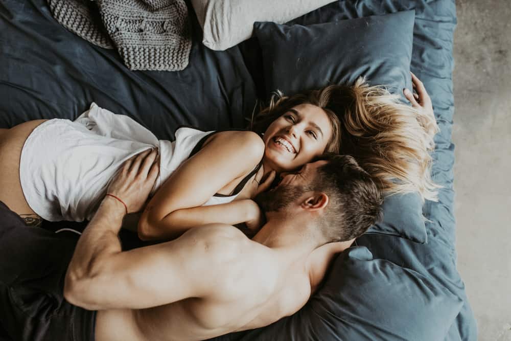 Vackra älska par som kysser i sängen