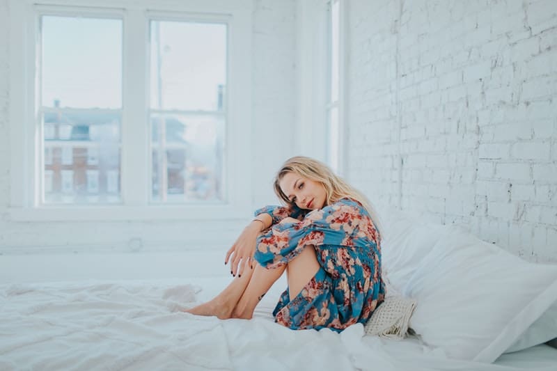 blond kvinna som sitter i sängen