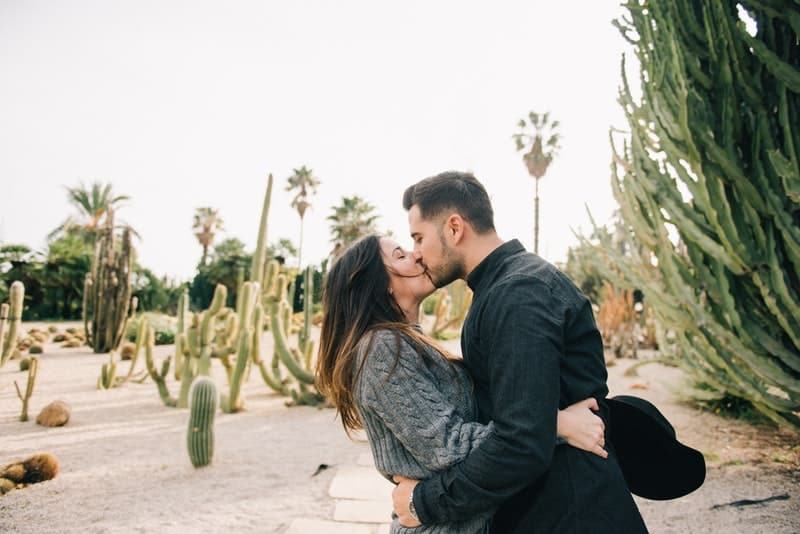 en man och en kvinna kysser på en kaktus