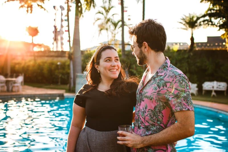 en man och en kvinna står vid poolen