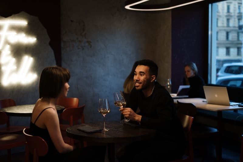ett kärleksfullt par sitter och pratar om vin