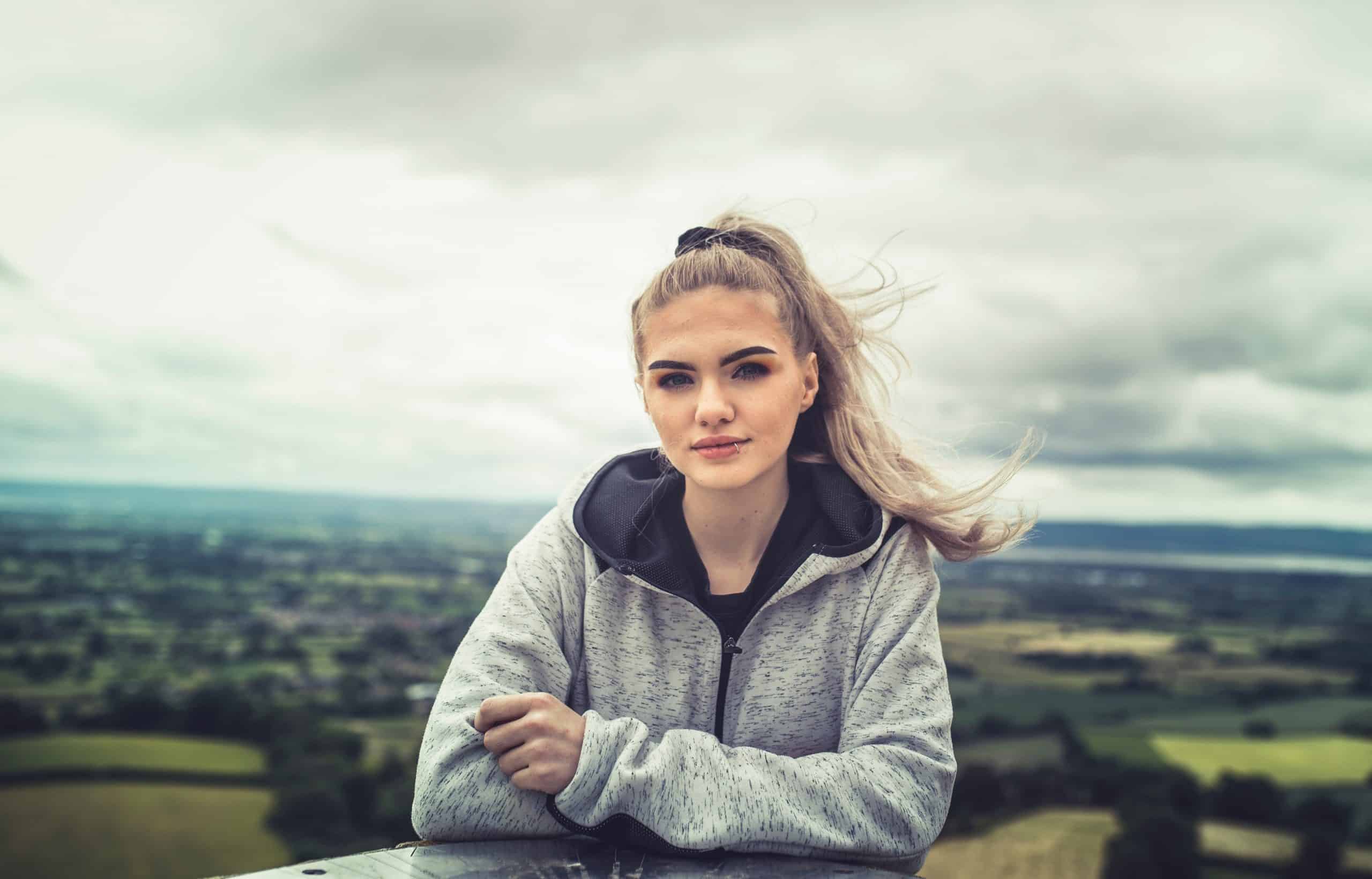 flicka i grå hoodie med naturen i bakgrunden