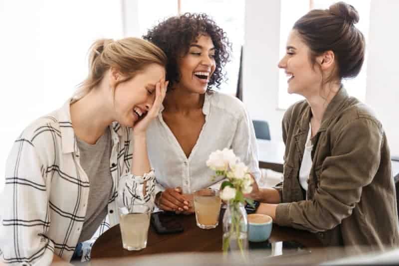 glada kvinnavänner som har en positiv konversation på kaféet