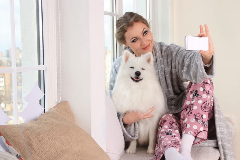 kvinna med hunden tar selfie foto