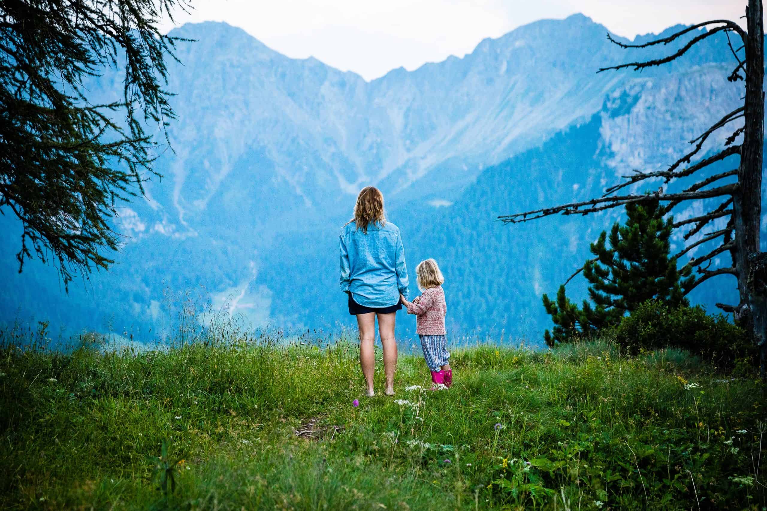 kvinna med sitt barn tittar på bergen