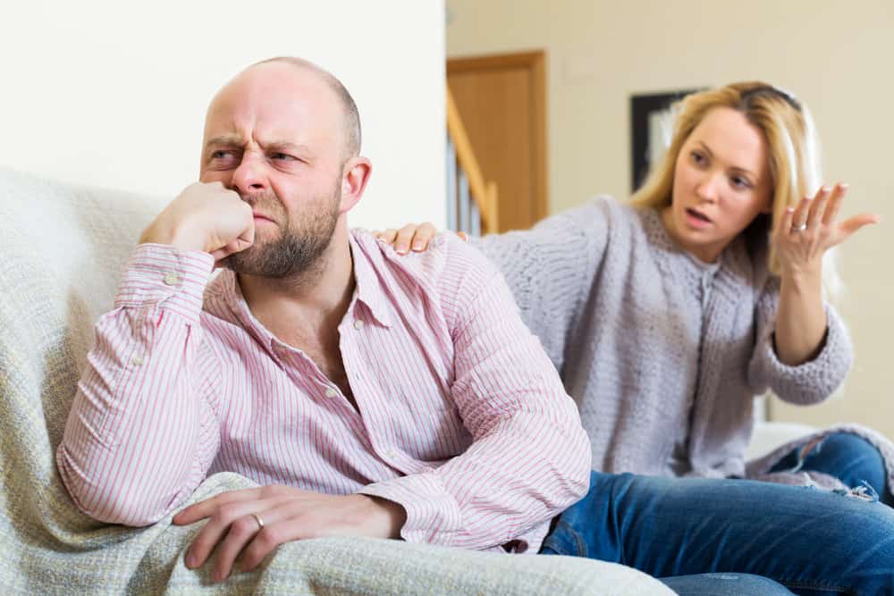 man and woman having quarrel in livingroom