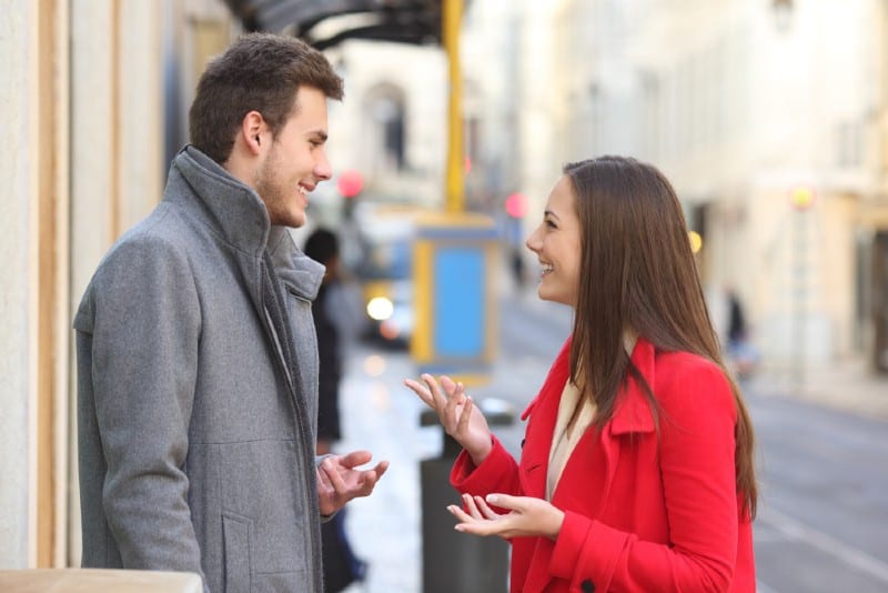 man och kvinna pratar på gatan