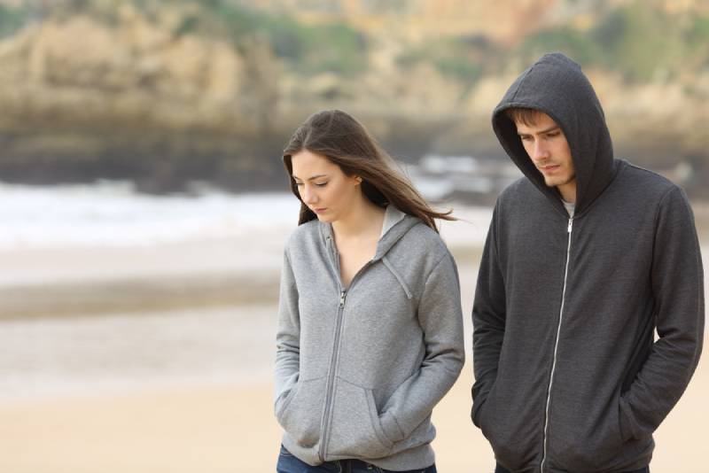 olyckliga par som går på stranden