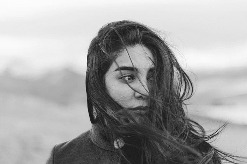 svartvitt foto av kvinna med hår som blåser i vinden