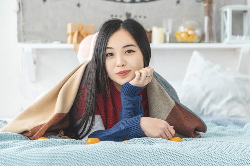 vacker asiatisk kvinna som ligger på sängen