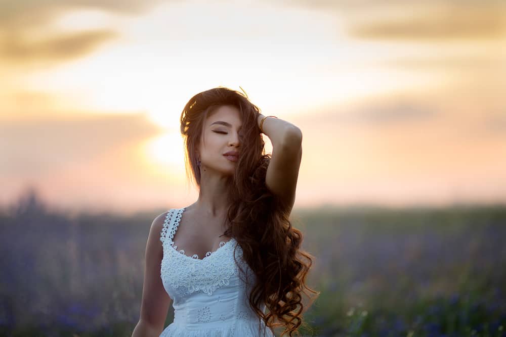 vacker flicka med långt hår vid solnedgången