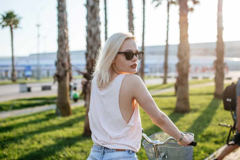 blond kvinna som cyklar vid havet på sommaren